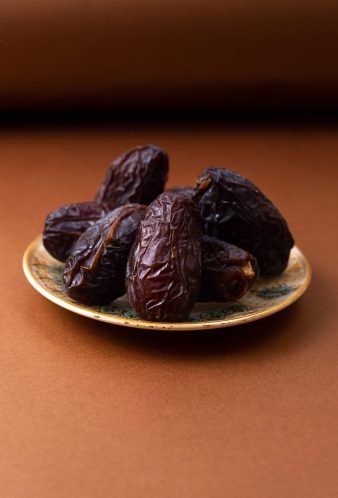 front-view-brown-xurma-sweet-tasty-inside-plate-brown-wooden-desk